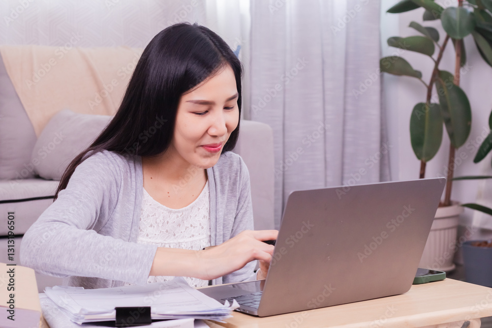 Asian happy female working at home calculate bookkeeping for tax declarations using modern technology laptop, well-organized planning financial payment for housing loan, women working paperwork bills Asian happy female working at home calculate bookkeeping for tax declarations using modern technology laptop, well-organized planning financial payment for housing loan, women working paperwork bills