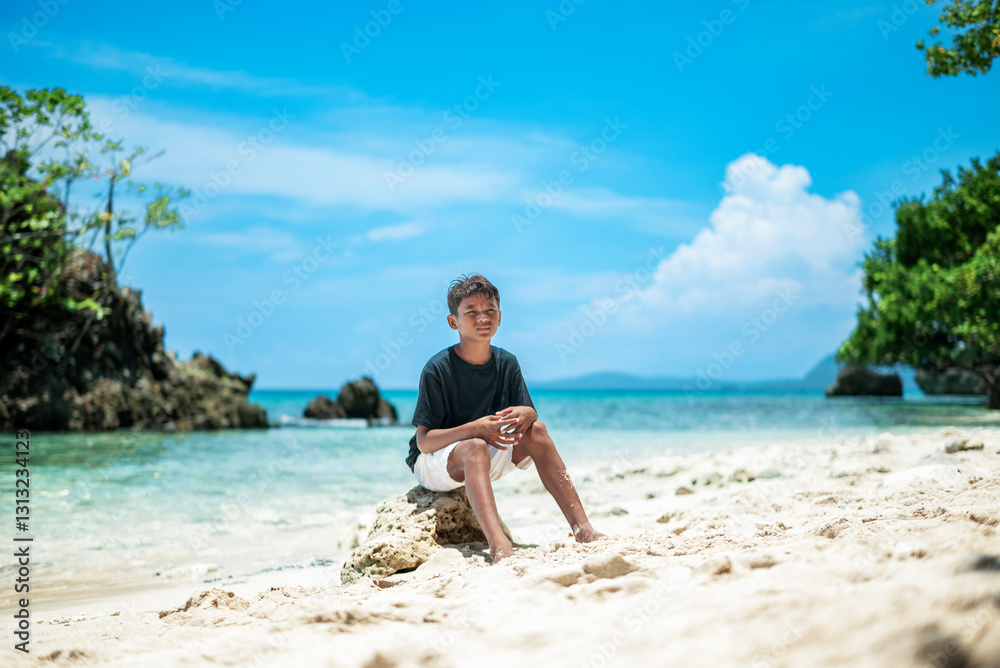 Obraz premium Boy on the beach with beautiful natural scenery background