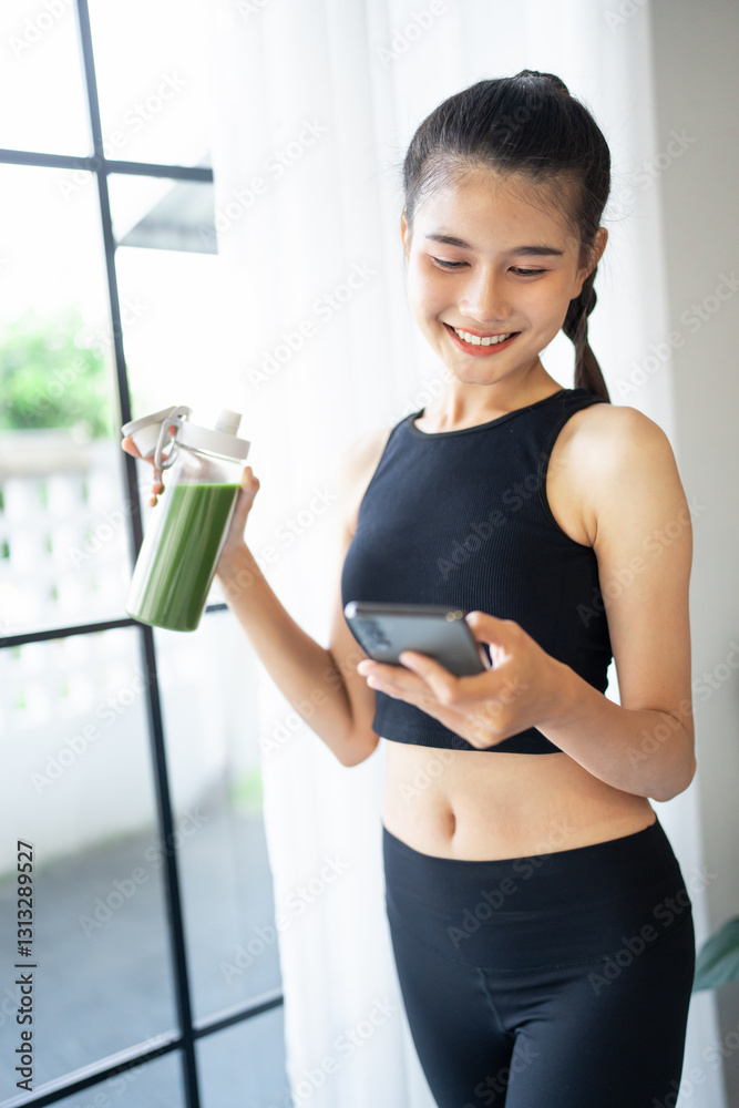 Fitness asian woman using smart phone and drinking organic green smoothie fruit detox for diet after workout exercise.training healthy lifestyle Fitness asian woman using smart phone and drinking organic green smoothie fruit detox for diet after workout exercise.training healthy lifestyle