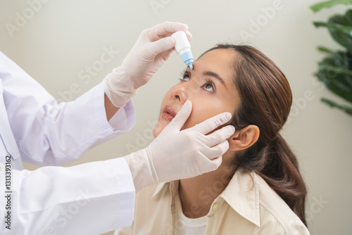Billede på lærred Health care concept, eye doctor eye drops to asian young woman patient, hand using medical eye drop to treat dry eye, suffering irritation or inflammation, allergy optical symptom at optic clinic