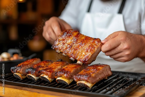 Chef presenting barbecued pork ribs on grill