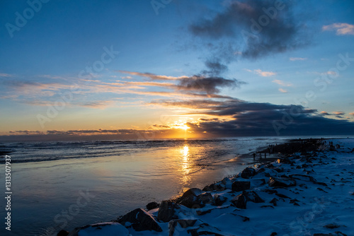Beatiful, golden hour sunlight is refracted in melting ice on diamond beach, near Jokulsarlon glacier lagoon in Southern Iceland.