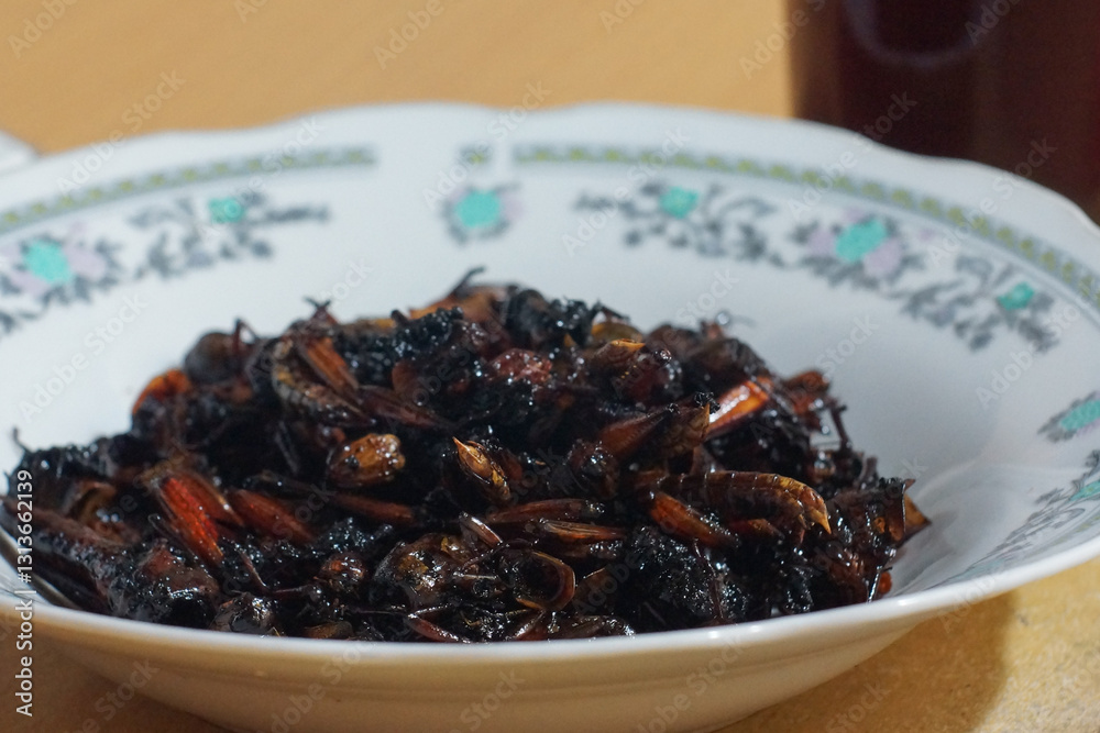 Traditional dish made from fried insects served in a decorative bowl Traditional dish made from fried insects served in a decorative bowl
