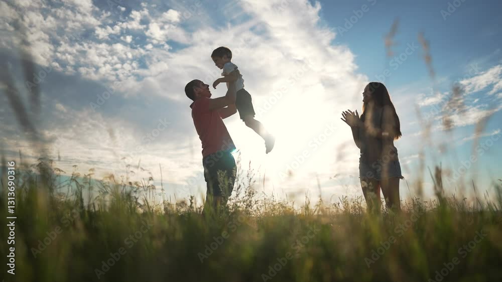 Happy child playing with father. Father lifts child high in air as mother smiles. Fun family moment outdoors. Child enjoys playtime with father mother. Happy family creates joyful memories together. Happy child playing with father. Father lifts child high in air as mother smiles. Fun family moment outdoors. Child enjoys playtime with father mother. Happy family creates joyful memories together.