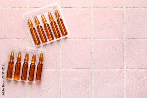 Medical ampules on pink til...