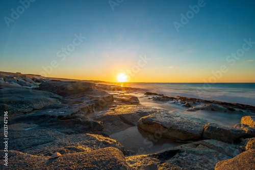 beautiful sunset with clear sky on a stony beach
