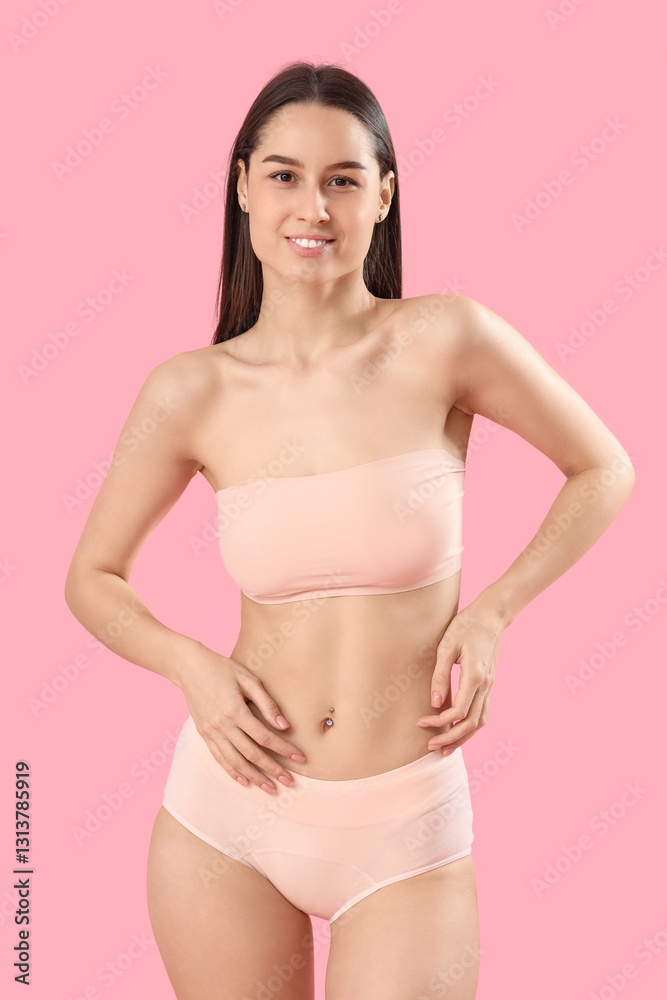 Fototapeta premium Slim young woman in cotton underwear on pink background