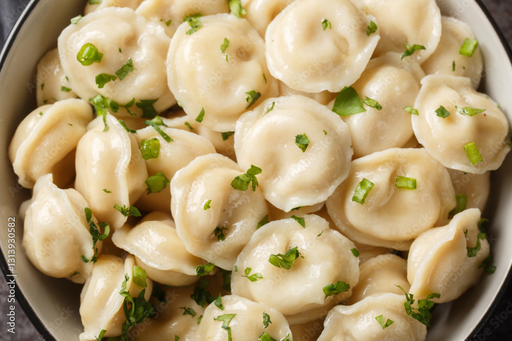 Pelmeni traditional russian dumplings with minced meat filling close-up on the table. Horizontal top view from above