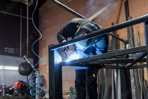 Dans un atelier de métallerie, gros plan sur les étincelles. Un homme qui est en train de couper des barres de métal. L'art et la précision des métalliers dans leur environnement de travail. photo