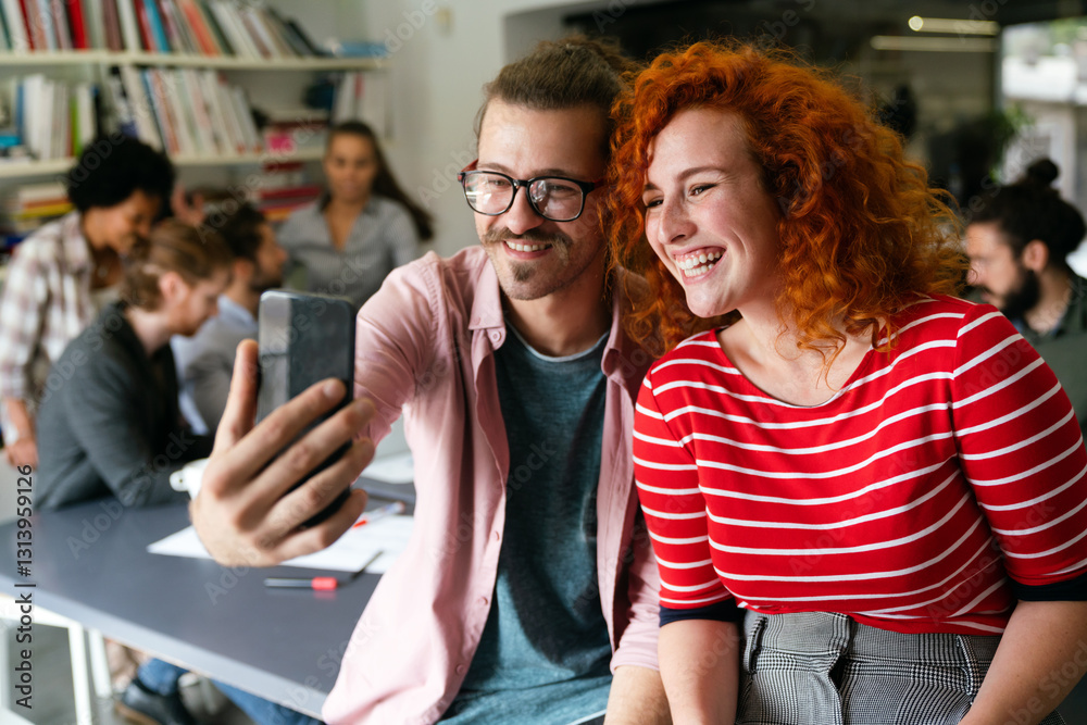 Friendly happy multiethnic coworker male and female having fun with smartphone, working together Friendly happy multiethnic coworker male and female having fun with smartphone, working together