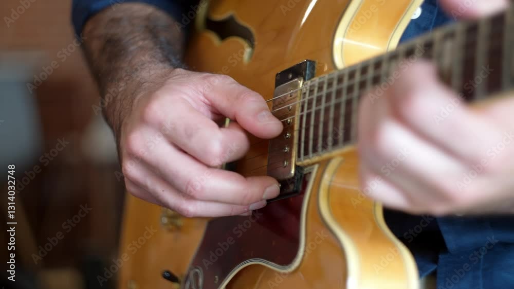 Unique view of a guitarist playing complicated melodies notes in an expensive electric guitar