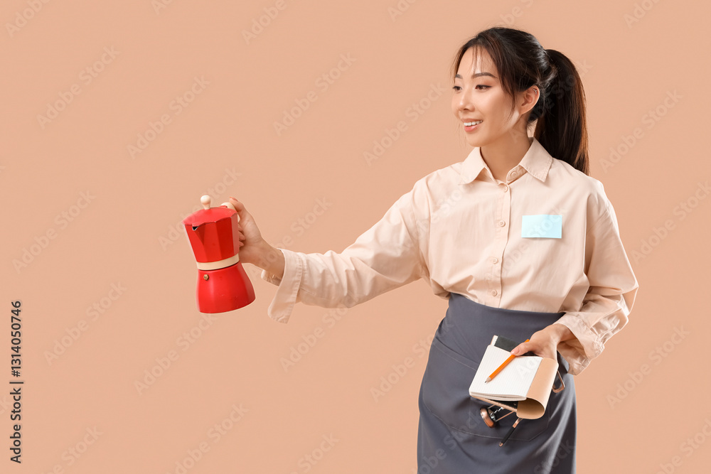 Young Asian smiling waitress with notebook and coffee pot on beige background Young Asian smiling waitress with notebook and coffee pot on beige background