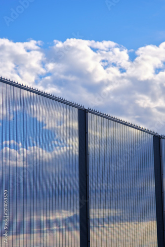 High security fence protecting property under cloudy sky