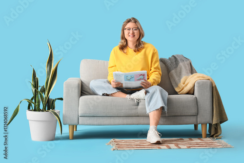 Young woman sitting on sofa...