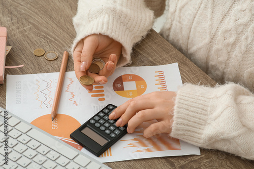 Woman with coins using calc...