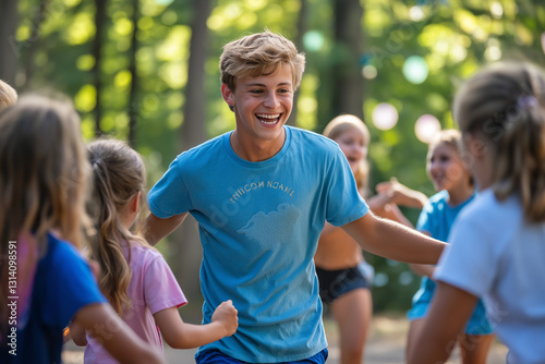 Happy young camp counselor playing with children outdoors.