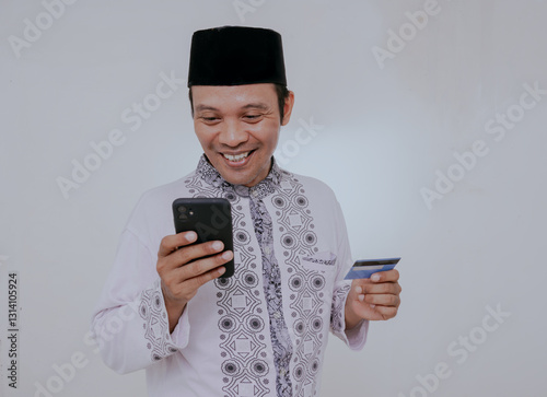 Photography Happy muslim asian man holding mobile phone and credit bank card shopping online, isolated on white background