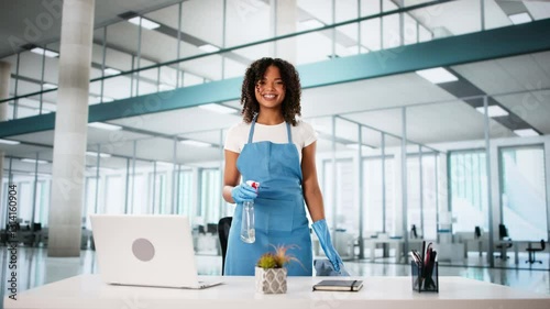 Portrait Of Happy Female Worker Cleaning Computer Desk With Spray And Sponge