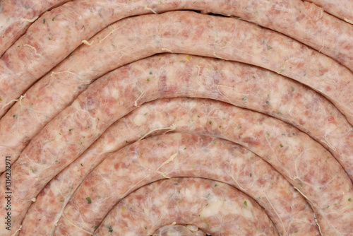 A close-up, top-down view of coiled raw sausages, highlighting their texture and preparation