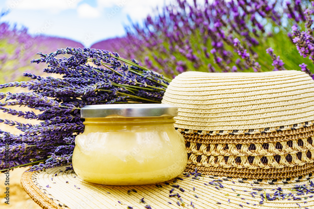 Summer hat and jar with honey at lavender field. Holidays in France.