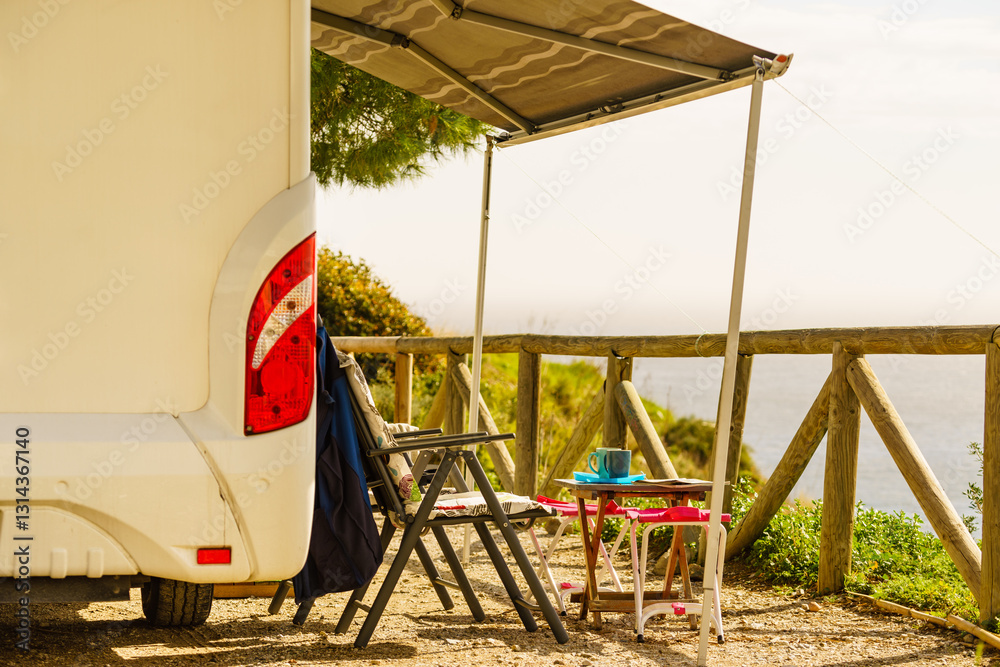 Camper and chairs on sea shore