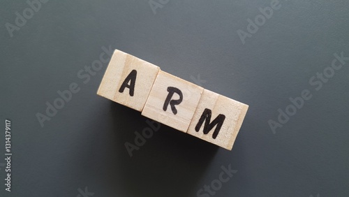 ARM acronym made of wooden letter cubes on dark background. Adjustable Rate Mortgage
