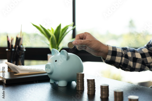 A man is managing the money he has saved in a piggy bank to pay his bills.

