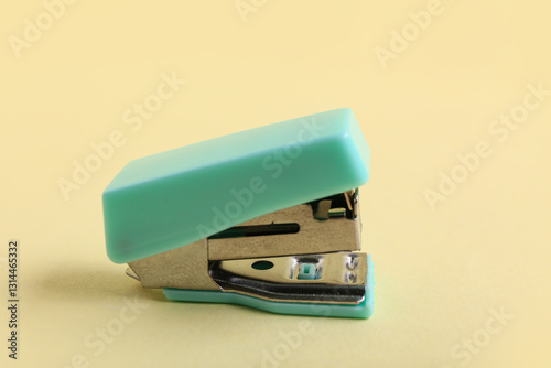 Turquoise stapler on yellow background