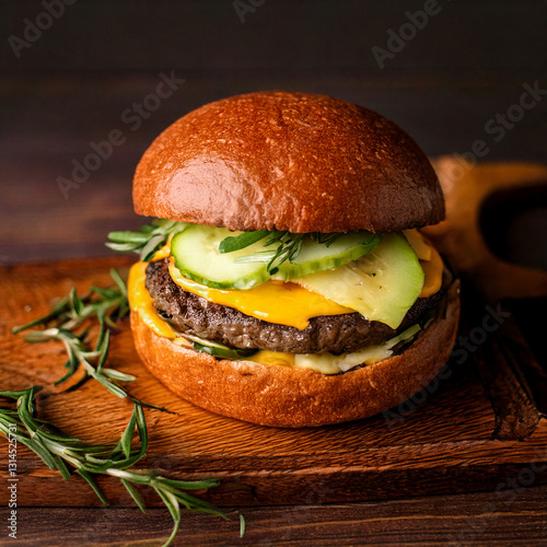 Obraz na płótnie Juicy hamburger on a rustic wooden background fastfood and foodtruck food with good quality w salonie