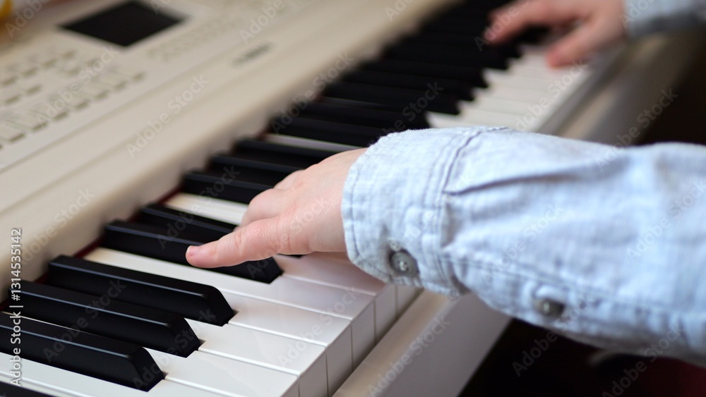 Fototapeta premium Children's hands on piano keys