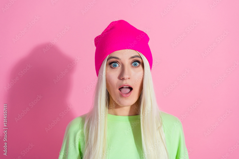 Charming young woman with surprised expression wearing a colorful beanie and stylish attire Charming young woman with surprised expression wearing a colorful beanie and stylish attire