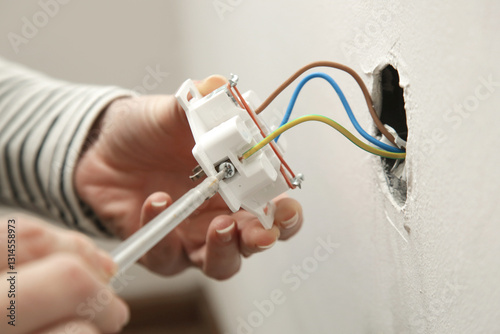 Electrical Outlet Repairing and Assembling - home improvement concepts. Master electrician installs a socket in the house. DIY home project.