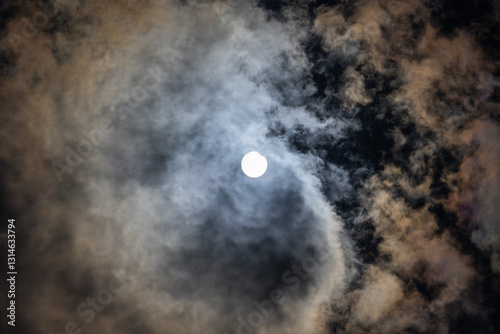 Obraz na płótnie dettaglio di un eclissi solare parziale, di giorno, a inizio estate 2021 dall'Italia, con cielo nuvoloso w salonie
