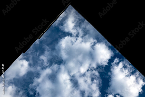 Obraz na płótnie cornice parziale nera di forma triangolare che copre parte del cielo azzurro e nuvoloso, di giorno w salonie