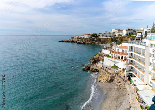 Stunning view of Nerja's coastline featuring white buildings and a picturesque beach on a sunny day.