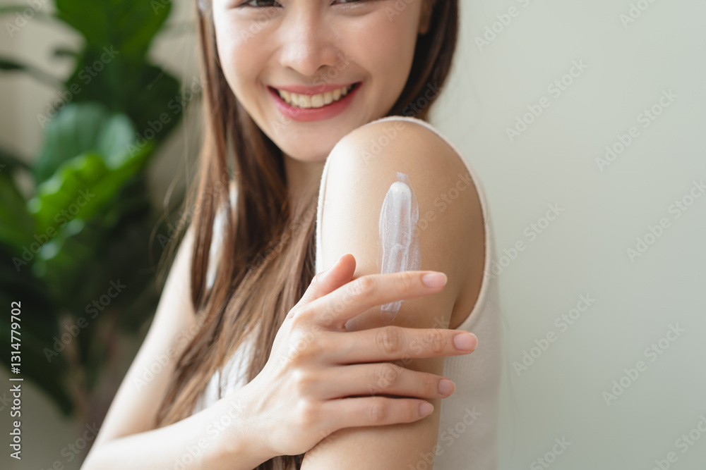Health skin care, beauty smile asian young woman, girl  hand applying, putting moisturizer on her arm, shoulder after shower bath at home. Skin body cream moisturizing lotion, routine in the morning.