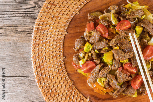 Obraz na płótnie Asian cuisine tasty stir fried beef veggies are beautifully served on round wooden platter for delicious meal. w salonie