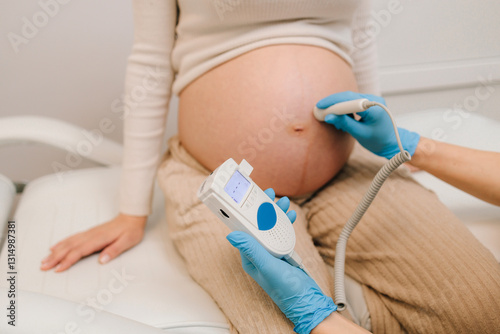 Schilderij op canvas Gynecologist listens to fetus heartbeat with fetal doppler in the clinic