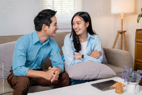 Young asian couple planning buying new house, discussing mortgage loan at home