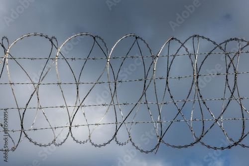 Stachdrahtzaun als grenze vor einem Himmel