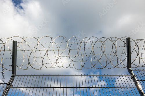 Stachdrahtzaun als grenze vor einem Himmel