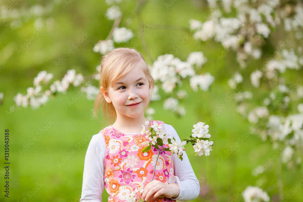 Little blonde girl admiring a blooming apple tree branch in a spring garden Little blonde girl admiring a blooming apple tree branch in a spring garden
