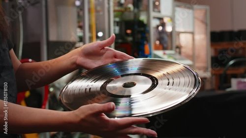 Hands skillfully checking the master stamp at a vinyl record pressing factory