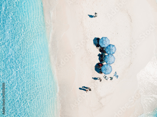 Aerial view of seascape atoll sandbank island with beach umbrellas in Maldives