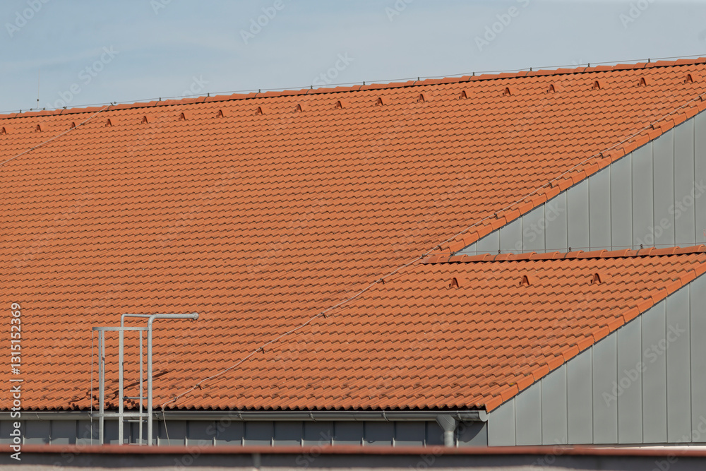 A beautiful building featuring a striking red tiled roof and an extended ladder prominently positioned on its side, showcasing its unique design A beautiful building featuring a striking red tiled roof and an extended ladder prominently positioned on its side, showcasing its unique design