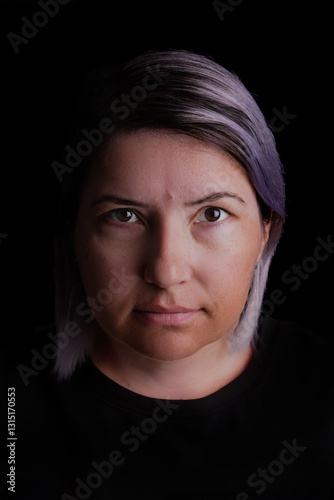 Studio portrait of a 40-year-old woman against a black background. Her confident expression and elegant presence create a timeless, professional image