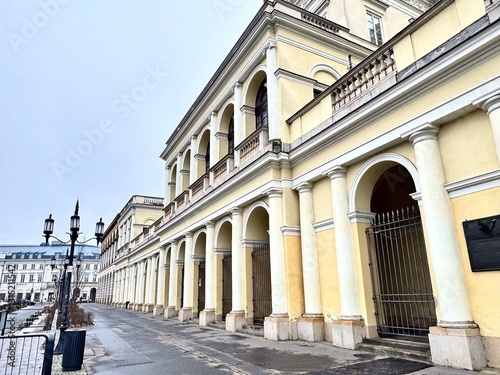view of the architecture of an old building on a Warsaw street with street lamps on a cloudy winter day
