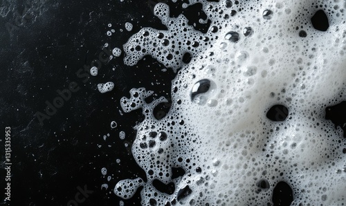 Soap suds on black background. White foam of soap on dark surface, pattern. Flat lay, top view, copy space