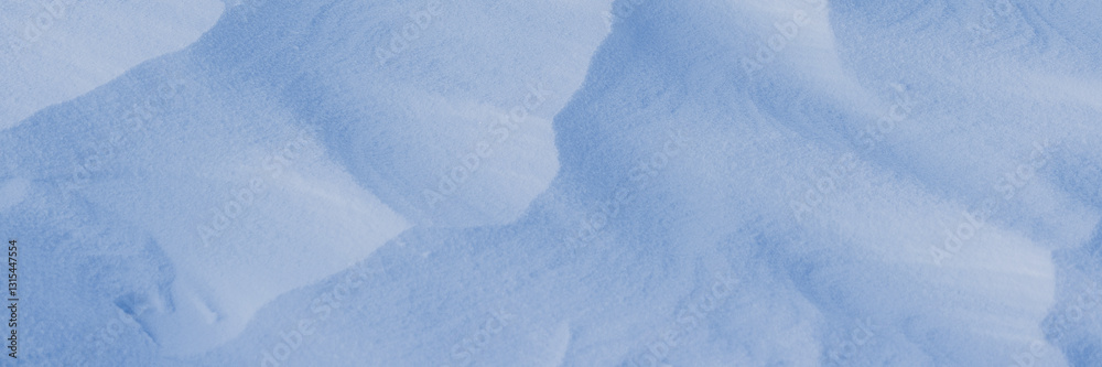 Obraz premium Beautiful winter background with snowy ground. Natural snow texture. Wind sculpted patterns on snow surface. Wide panoramic texture for background and design.