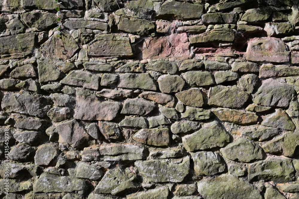 A wall made of stone with moss growing on it A wall made of stone with moss growing on it